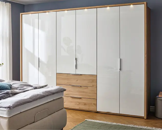 Moderner Kleiderschrank mit weißer Glasfront, integrierten Holzschubladen und klarer Linienführung. Hochwertige Schlafzimmermöbel mit viel Stauraum, zeitlosem Design und eleganter Kombination aus Holz und Glas.